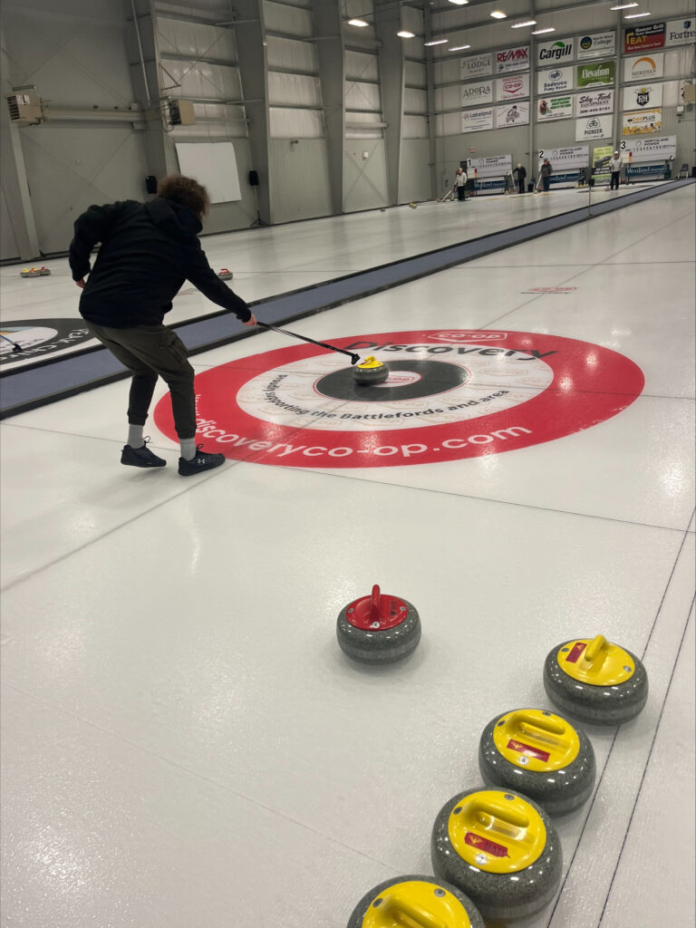 A curler marks a shot in the house.